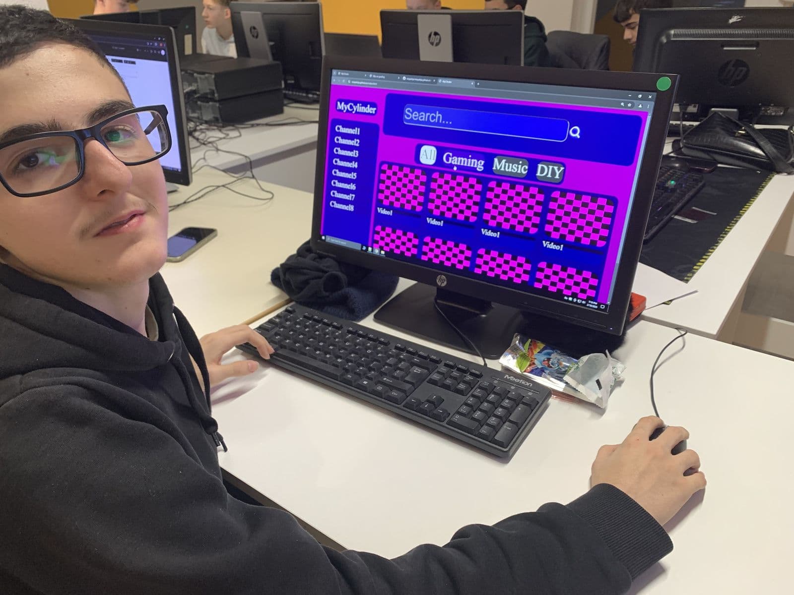 Teenager am Computer mit einer selbst gestalteten und gebauten Video-Website